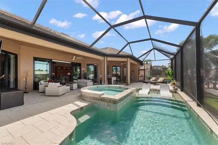 Integrated pool / spa with an outdoor lounge area, a sunroom, glass enclosure, and a patio area