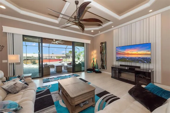 Living area with a ceiling fan, wood finished floors, a sunroom, recessed lighting, and ornamental molding