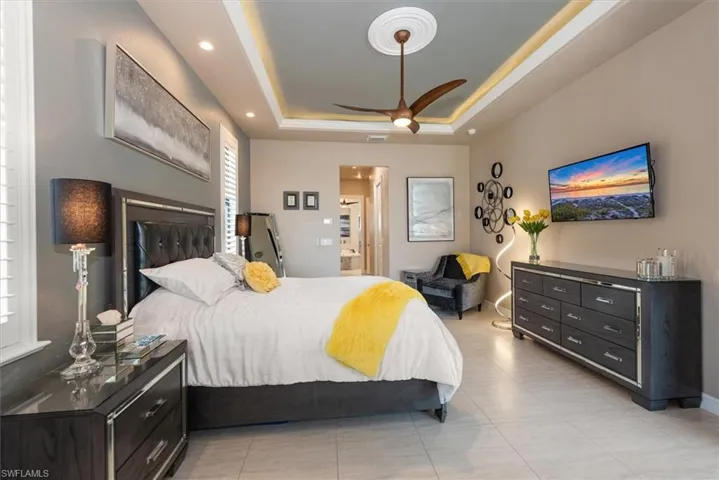Bedroom with a ceiling fan, recessed lighting, and a raised ceiling