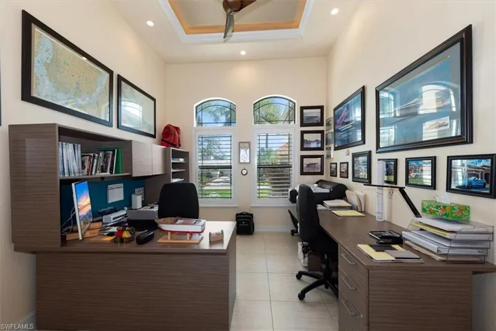 Office area with a high ceiling and light tile patterned floors
