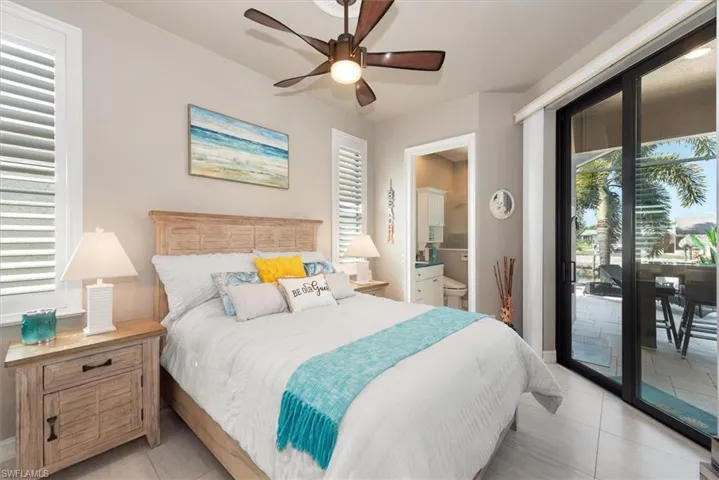 Bedroom featuring access to exterior, ceiling fan, connected bathroom, and light tile patterned floors