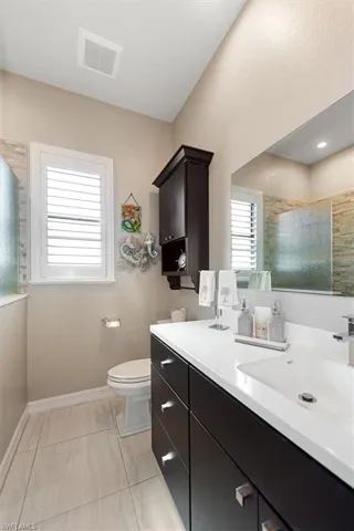 Bathroom featuring vanity, a shower with door, and light tile patterned flooring