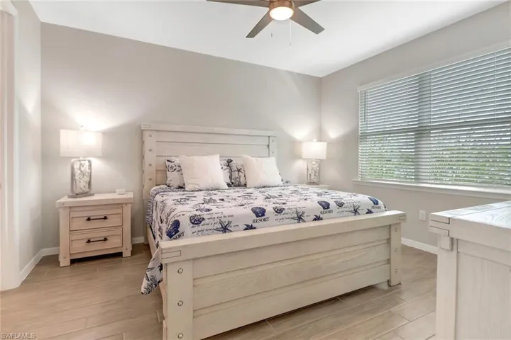 Bedroom featuring ceiling fan, lake view