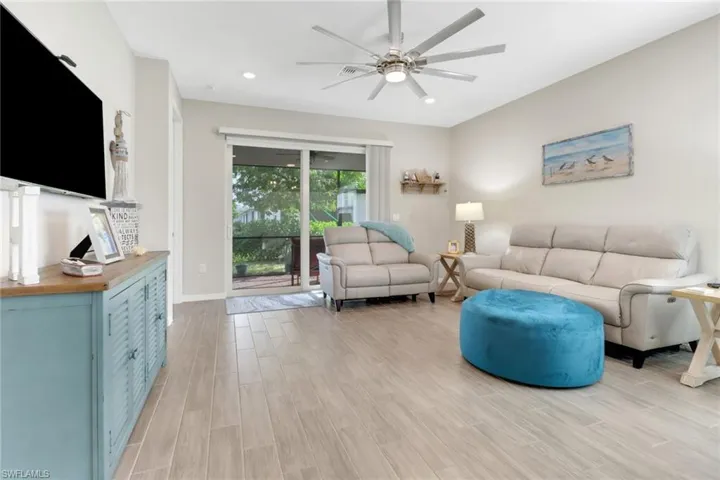 Living room with ceiling fan and tile flooring, hurricane slider to lanai