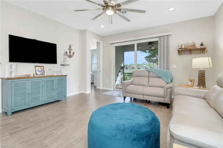 Living room featuring ceiling fan, tile floors
