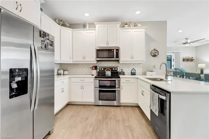 Kitchen, double oven, white cabinetry, and stainless steel appliances