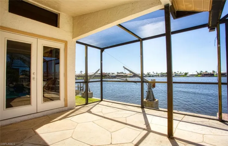 Unfurnished sunroom with french doors, a water view, and a healthy amount of sunlight