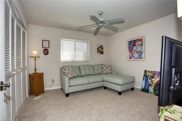 Living area featuring carpet, ceiling fan, and baseboards