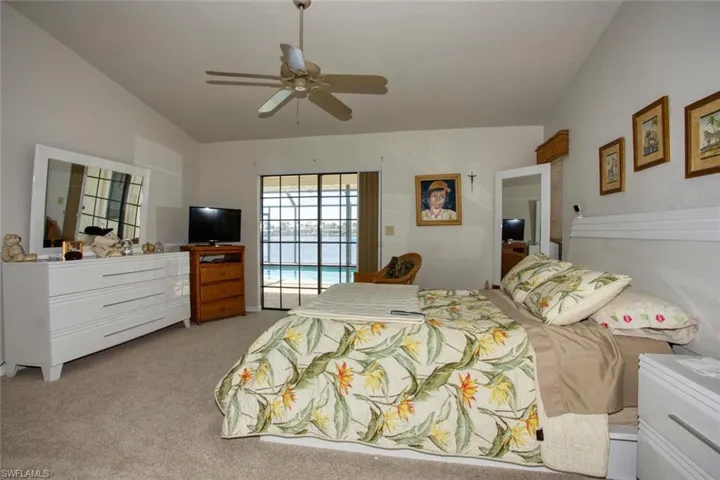 Carpeted bedroom with ceiling fan and access to outside