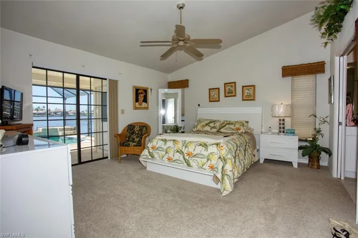 Bedroom featuring carpet floors, access to exterior, a ceiling fan, and lofted ceiling