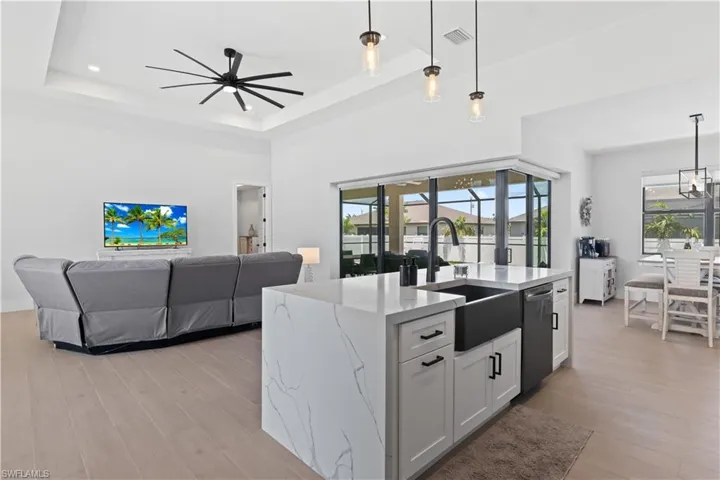 Kitchen featuring dishwasher, a ceiling fan, plenty of natural light, and light stone countertops