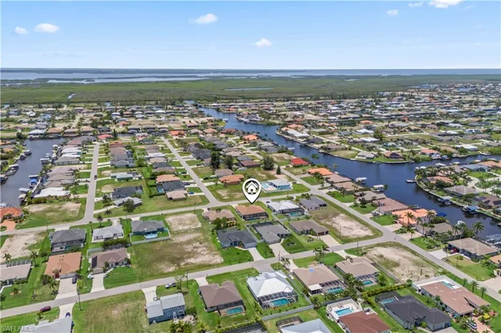 Aerial view of property's location with a large body of water and nearby suburban area
