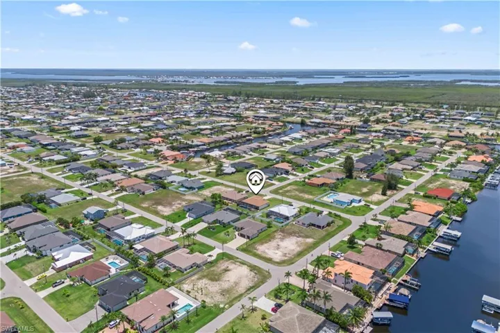 Aerial view of property's location with a nearby body of water and nearby suburban area
