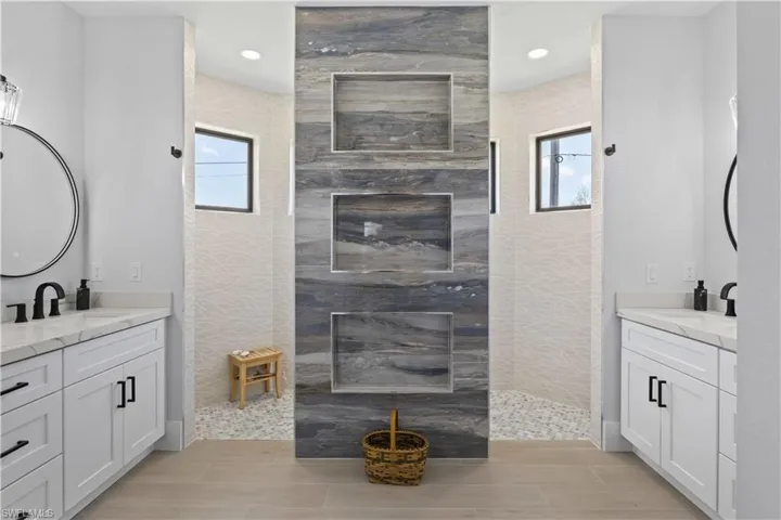 Bathroom with a walk in shower, two vanities, recessed lighting, and wood tiled floors
