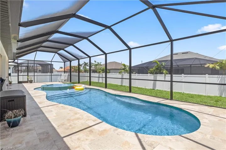 View of swimming pool featuring a patio, a fenced backyard, a jacuzzi, a residential view, and glass enclosure