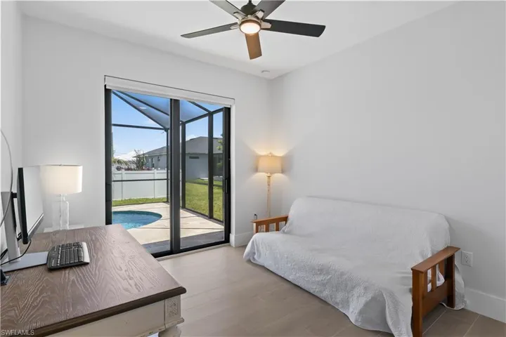 Bedroom with access to exterior, a ceiling fan, and wood finished floors
