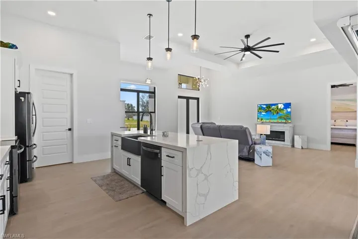 Kitchen featuring appliances with stainless steel finishes, open floor plan, light wood-style flooring, recessed lighting, and white cabinetry