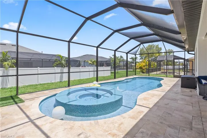 View of swimming pool featuring a patio, a hot tub, a residential view, and glass enclosure