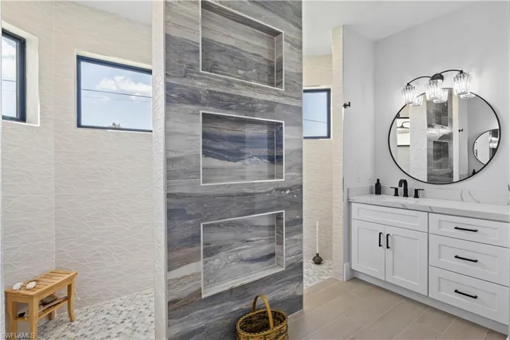 Full bathroom featuring vanity, a shower, and wood finished floors