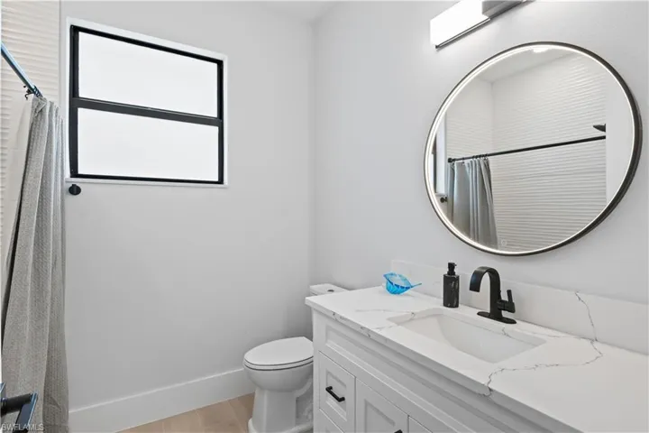 Full bath featuring vanity, wood finished floors, and curtained shower