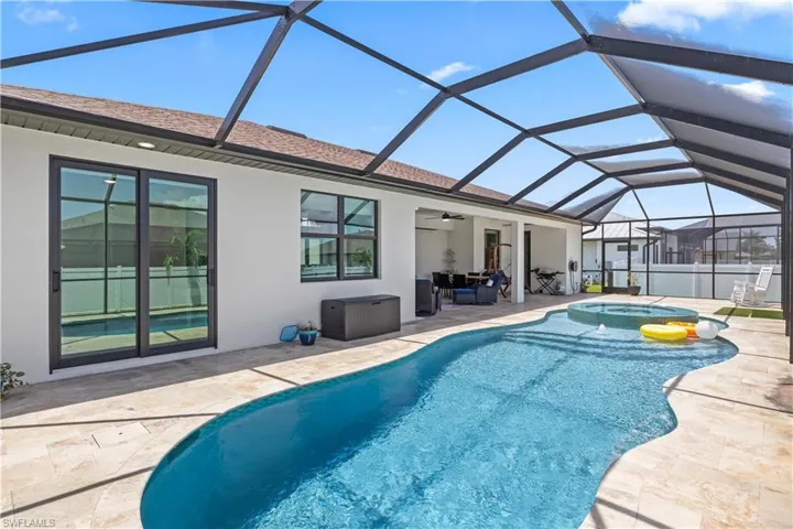 Outdoor pool with an in-ground hot tub, a patio, ceiling fan, and a lanai