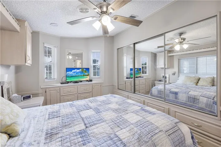Bedroom featuring ceiling fan, a closet, and a textured ceiling