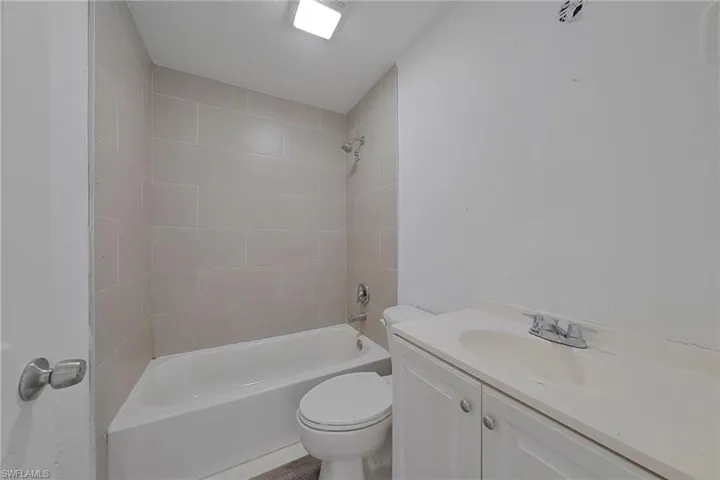 Full bathroom featuring toilet, vanity, and tiled shower / bath