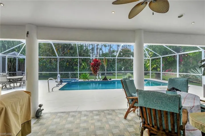 Screened-in lanai featuring a swimming pool, integrated spa, and tile flooring
