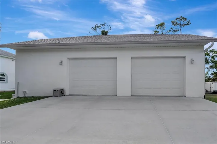 Two-car garage featuring a stucco exterior and a concrete driveway