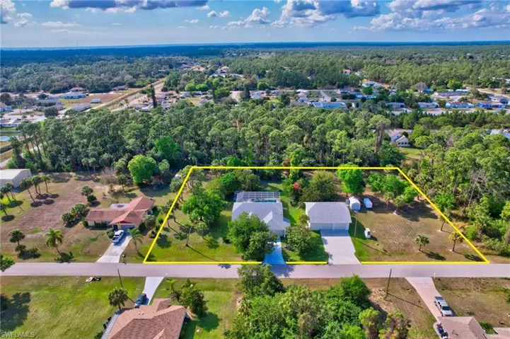 Expansive property featuring a single-story residence with an attached garage, a detached garage, and a swimming pool