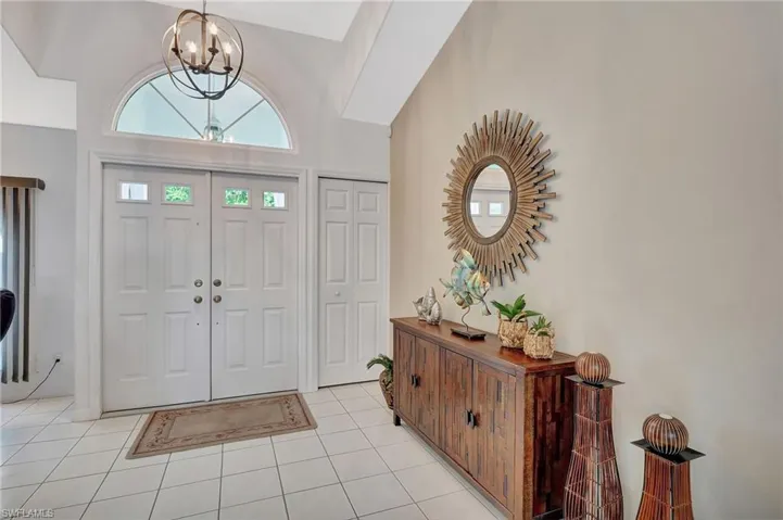 Arched transom window above double entry doors with decorative glass panels
