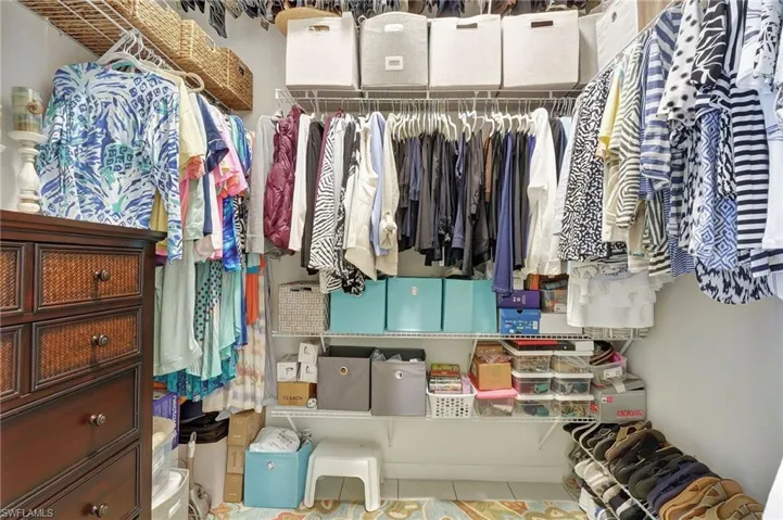 Custom closet system featuring multiple hanging rods, wire shelving, and overhead storage
