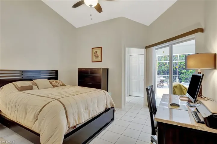 Vaulted ceiling bedroom with white tile flooring