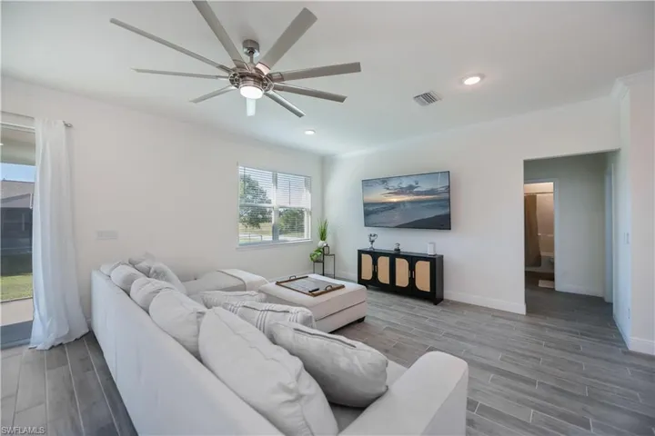 Living area with crown molding, a ceiling fan, and recessed lighting