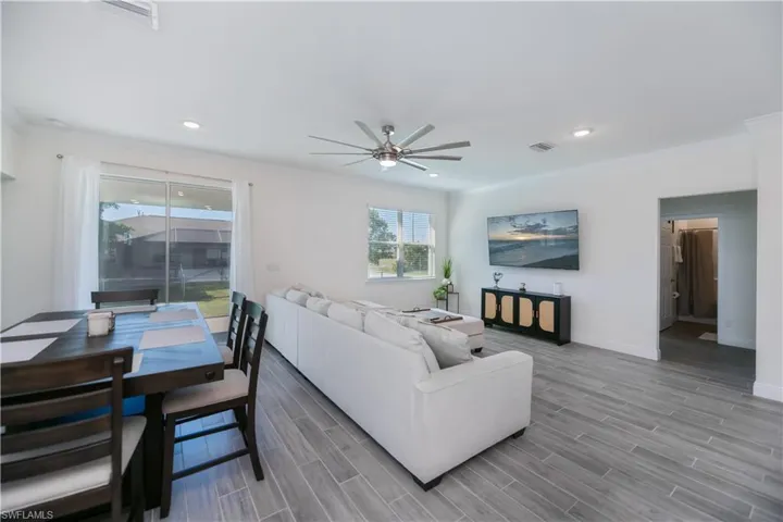 Living area with crown molding, ceiling fan, and recessed lighting