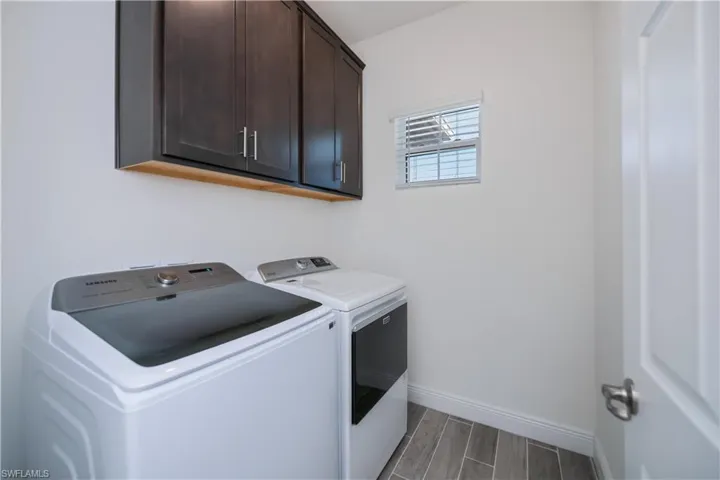 Laundry area featuring cabinet space, and washing machine and clothes dryer