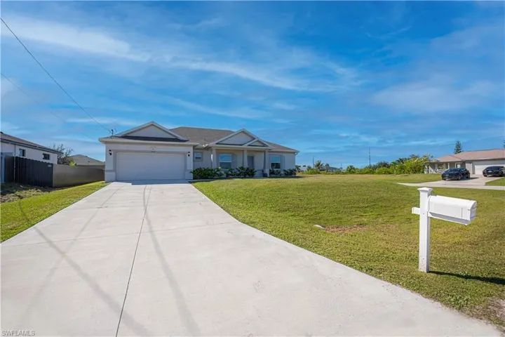 Ranch-style house featuring concrete driveway and an attached garage