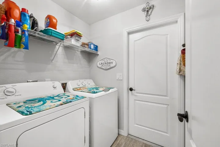 Laundry area featuring washing machine and dryer and light wood finished floors