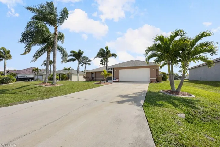 Ranch-style house with concrete driveway, an attached garage, a front lawn, and stucco siding
