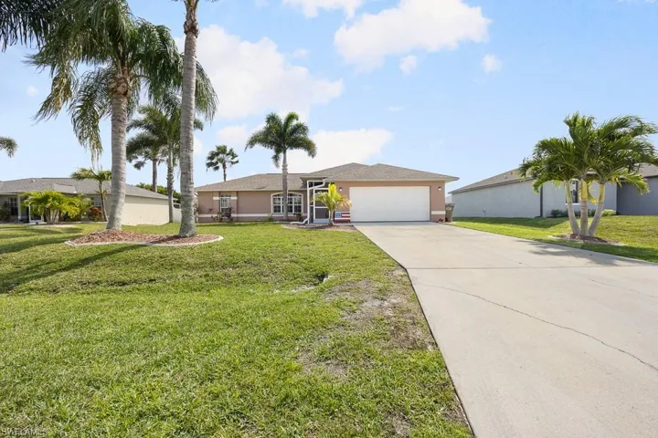 Ranch-style home with concrete driveway, a front yard, a garage, and stucco siding