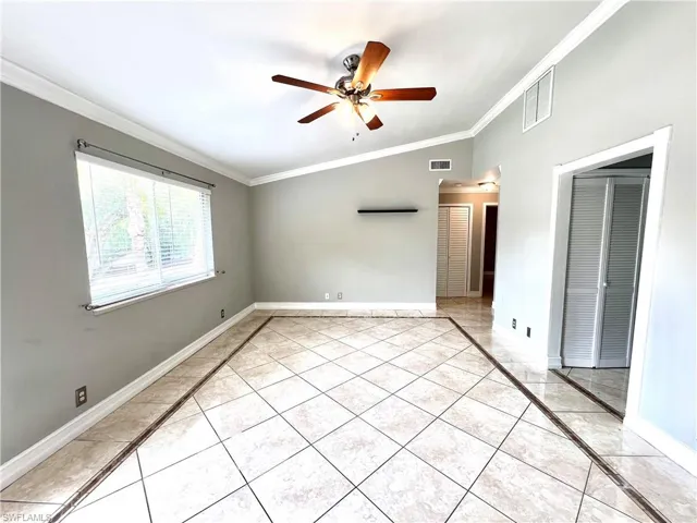 Unfurnished room featuring ornamental molding, ceiling fan, and light tile flooring