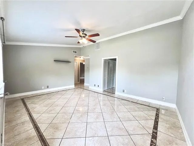 Unfurnished room featuring ceiling fan, crown molding, and light tile flooring