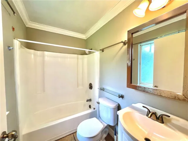 Full bathroom with shower / bathing tub combination, crown molding, toilet, and vanity with extensive cabinet space