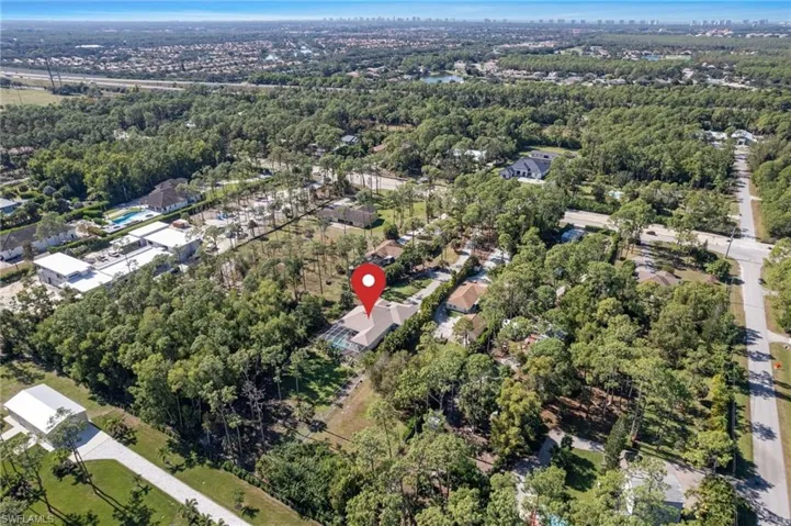 Aerial view of property and surrounding area featuring a tree filled landscape