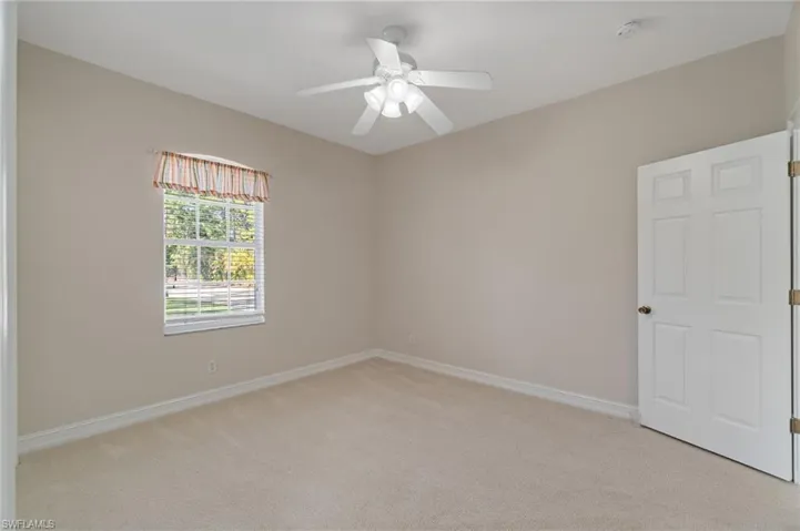 Bedroom featuring light carpet and ceiling fan, ensuite/shared bathroom