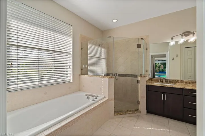Main Bathroom featuring vanity, a bathtub, a shower stall, light tile patterned flooring, and recessed lighting