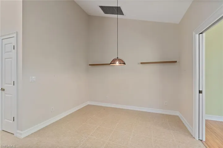 Unfurnished dining area with high vaulted ceiling and light flooring