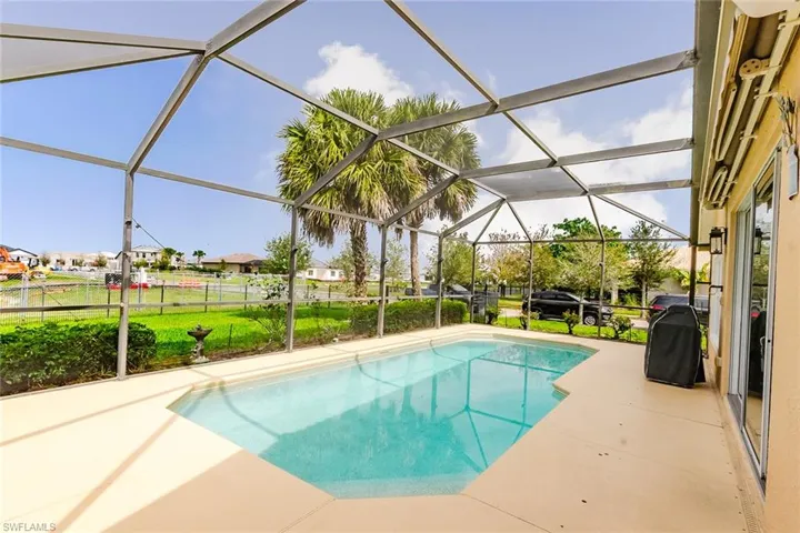Outdoor pool featuring a sunroom, a patio, a lanai, grilling area, and a residential view
