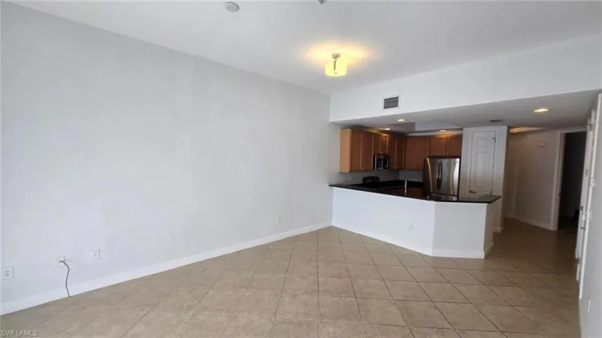 Kitchen featuring light tile patterned floors, stainless steel appliances, and kitchen peninsula