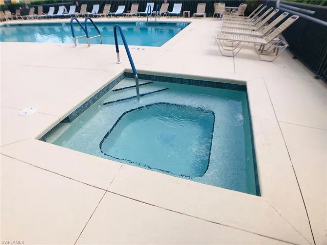 View of pool with a hot tub
